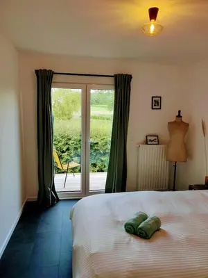 a bedroom with a bed and a sliding glass door at Wetterdelle Lodge in Heers