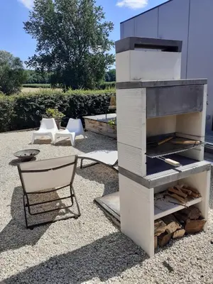 a outdoor oven with a chair and a table at Wetterdelle Lodge in Heers