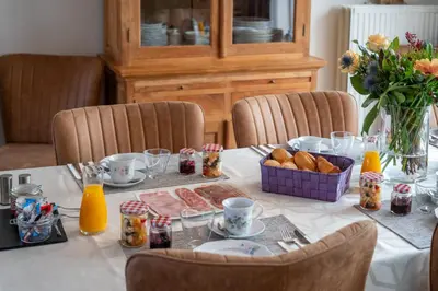 a table with a white table cloth with food on it at Bed & Breakfast 't Vèèrke in Dilsen-Stokkem