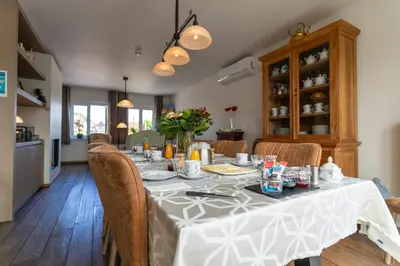 a dining room with a long table with chairs at Bed & Breakfast 't Vèèrke in Dilsen-Stokkem