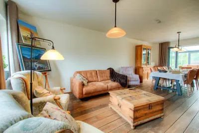a living room filled with furniture and a table at Bed & Breakfast 't Vèèrke in Dilsen-Stokkem
