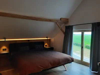 a bedroom with a bed and a large window at De Bonderbei in Wellen