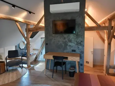 a room with a table and a tv on a wall at De Bonderbei in Wellen