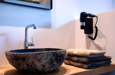 a bathroom sink with a faucet and some towels at De Bonderbei in Wellen