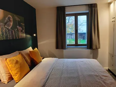 a bedroom with a bed with yellow pillows and a window at De Bonderbei in Wellen