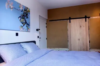 a bedroom with a bed and a sliding glass door at De Bonderbei in Wellen