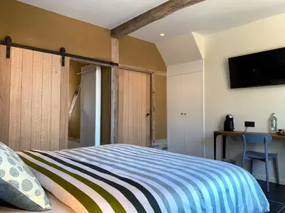 a bedroom with a bed and a tv on the wall at De Bonderbei in Wellen