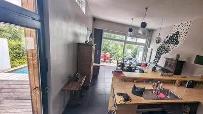 a kitchen with a table and a sink in a room at Maison à la porte des Ardennes in Verviers