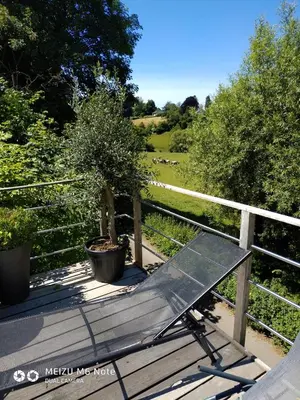 a bench sitting on a wooden deck next to a fence at Maison à la porte des Ardennes in Verviers