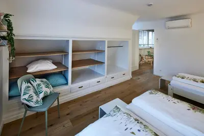 a room with a bedroom with a bed and a chair at Vakantiehuis Elisa in Alken
