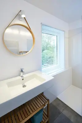 a white bathroom with a sink and a mirror at Vakantiehuis Elisa in Alken