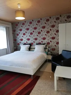 a bedroom with a bed with red flowers on the wall at CASA Victoria in Kuringen