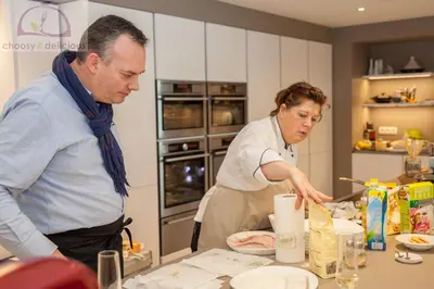 a man and a woman preparing food in a kitchen at CASA Victoria in Kuringen