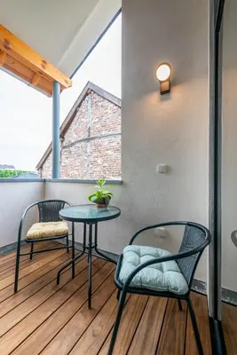 a balcony with two chairs and a table at De Lokroep in Heers