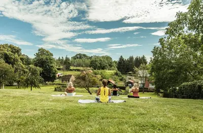 a group of girls sitting on the grass in a park at Boerderaaj vakantiewoning in Bilzen