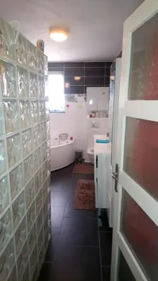 a bathroom with a tub and a toilet and a door at Spacious House in Tongeren in Tongeren