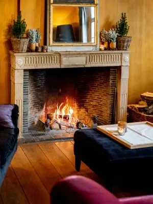 a fireplace in a living room with a fire place at Hotel De Barrier in Houthalen-Helchteren