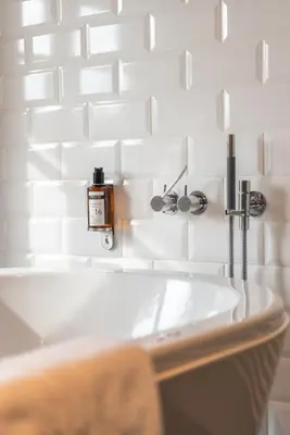 a bathroom with a sink and white tiles at Hotel De Barrier in Houthalen-Helchteren