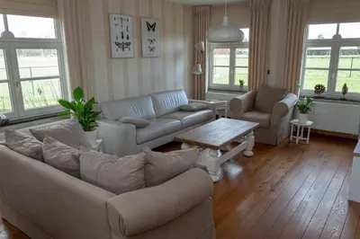 a living room with a couch and a table at Vakantiewoning Pelterheggen in Grote Heide