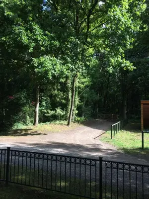 a fence next to a road with trees at Chalet Belvedere in Lanaken in Lanaken