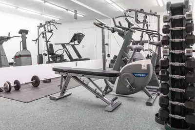 a gym with several tread machines and a mirror at Esplanada Studios in Genk