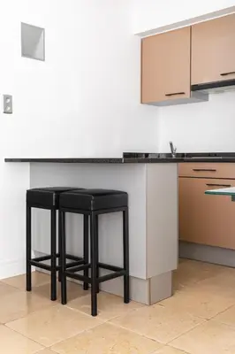 a kitchen with two black stools in front of a counter at Esplanada Studios in Genk