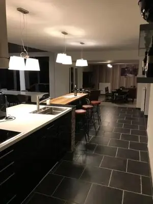 a kitchen with a counter and some stools in it at Bij de lindeboom in Maaseik