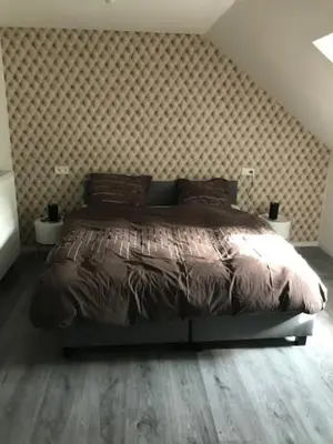a bedroom with a bed with a wooden floor at Bij de lindeboom in Maaseik