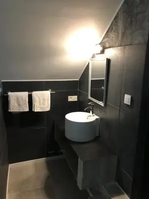 a bathroom with a sink and a mirror and towels at Bij de lindeboom in Maaseik