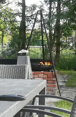 a fire pit in a yard with a table and chairs at Bij de lindeboom in Maaseik