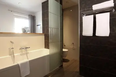 a bathroom with a tub and a sink and a toilet at B&B 4 Seasons in Riemst