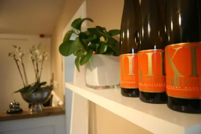 two bottles of wine sitting on a shelf with a plant at B&B 4 Seasons in Riemst