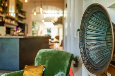 a green chair and a mirror in a room at BareFoodGIULIA - Inspiration Hotel in Hasselt