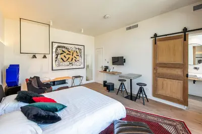 a bedroom with a large bed and a desk at BareFoodGIULIA - Inspiration Hotel in Hasselt