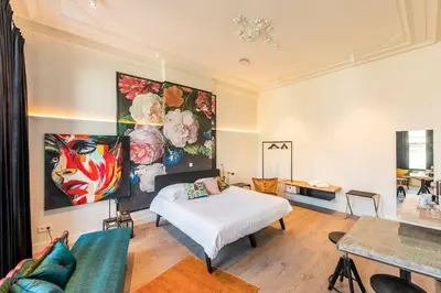 a bedroom with a bed and a painting on the wall at BareFoodGIULIA - Inspiration Hotel in Hasselt
