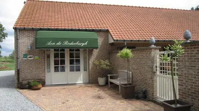 a brick building with a green awning and a door at Vakantiehuis Aen de Roderburgh in Maaseik