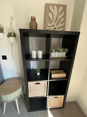 a black book shelf with plants and a stool at GT Lounge in Heusden - Zolder