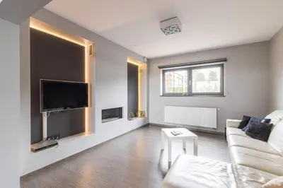 a living room with a couch and a tv at La Maison de Marie in Borgloon
