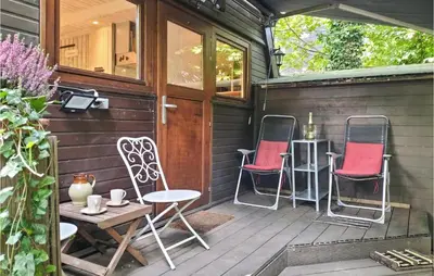 a porch with two chairs and a table on a house at Awesome Home In Rekem-Lanaken With Wifi in Bovenwezet