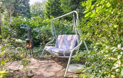 a swinging chair sitting in a garden next to a bush at Awesome Home In Rekem-Lanaken With Wifi in Bovenwezet