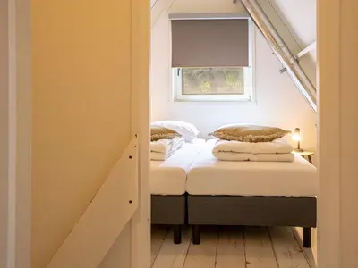 two beds in a small room with a window at Boshuisje Rekem - Luka in Lanaken