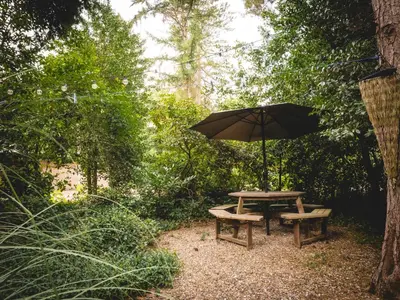 a picnic table and bench with an umbrella at Boshuisje Rekem - Luka in Lanaken