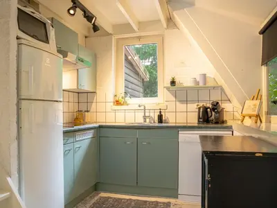 a kitchen with blue cabinets and a white refrigerator at Boshuisje Rekem - Luka in Lanaken