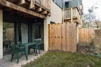 a patio with a table and chairs and a wooden fence at Center Parcs Erperheide in Peer