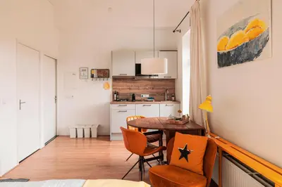 a room with a table and chairs and a kitchen at Mille Fleur Apartments in Voeren