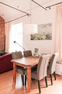 a dining room with a wooden table and chairs at Mille Fleur Apartments in Voeren