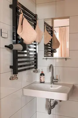 a white bathroom with a sink and a mirror at Mille Fleur Apartments in Voeren