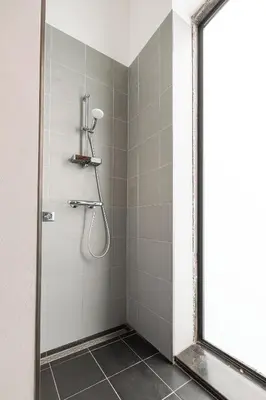 a shower with a glass door in a bathroom at Mille Fleur Apartments in Voeren