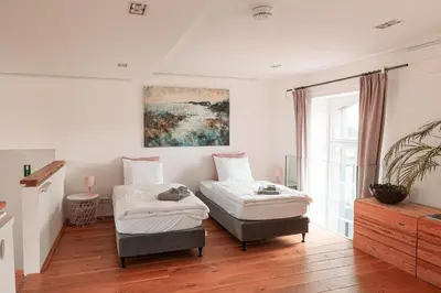 a room with two beds and a chair in it at Mille Fleur Apartments in Voeren