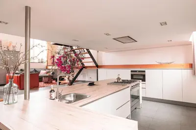 a kitchen with white cabinets and a sink at Mille Fleur Apartments in Voeren